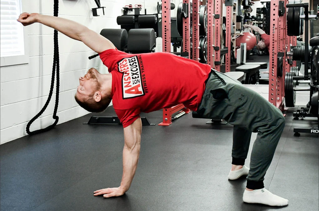 Bennett Dahl demonstrating a one-arm bridge in the Answers Not Excuses gym